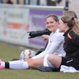 Spielerinnen sitzen am Rand.