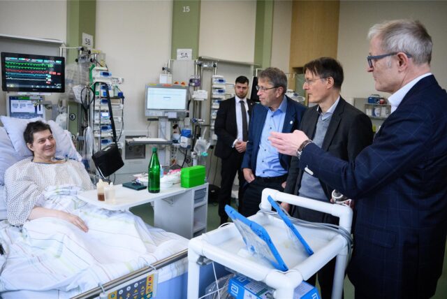 Karl Lauterbach (2.v.r-l, SPD), Bundesminister für Gesundheit, wird von Heyo K. Kroemer, Vorstandsvorsitzender der Charité, und Volkmar Falk (r), Direktor der Klinik für Herz-, Thorax- und Gefäßchirurgie, durch das Deutsche Herzzentrum der Charité geführt und unterhält sich dort mit dem Patienten Oliver S., dem nach einer lebensbedrohlichen Herzmuskelentzündung ein Herzunterstützungssystem implantiert wurde.