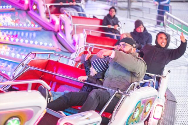 Ein Mann und ein Kind sitzen in einem Fahrgeschäft auf der Bergkamener Kirmes.