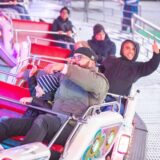 Ein Mann und ein Kind sitzen in einem Fahrgeschäft auf der Bergkamener Kirmes.