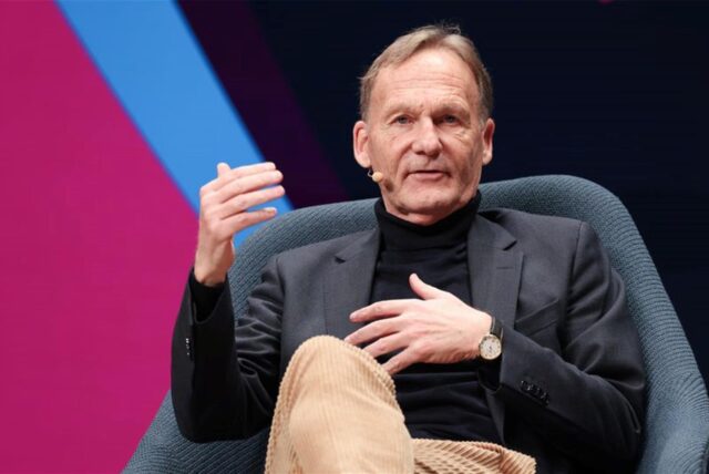 Hans-Joachim Watzke, Vorsitzender der BVB-Geschäftsführung und Chef der DFL sitzt bei einer Podiumsdiskussion in einem Sessel.