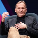 Hans-Joachim Watzke, Vorsitzender der BVB-Geschäftsführung und Chef der DFL sitzt bei einer Podiumsdiskussion in einem Sessel.