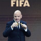 Gianni Infantino hält einen Schlüssel in der Hand und steht neben der Trophäe der Klub-WM.