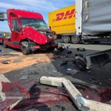 Ein zerstörter roter Transporter steht auf der A1 am Kamener Kreuz hinter einem Lkw.