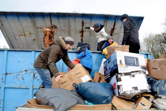 Altpapier- und Altkleiderspenden werden in einen Großcontainer umgeladen.