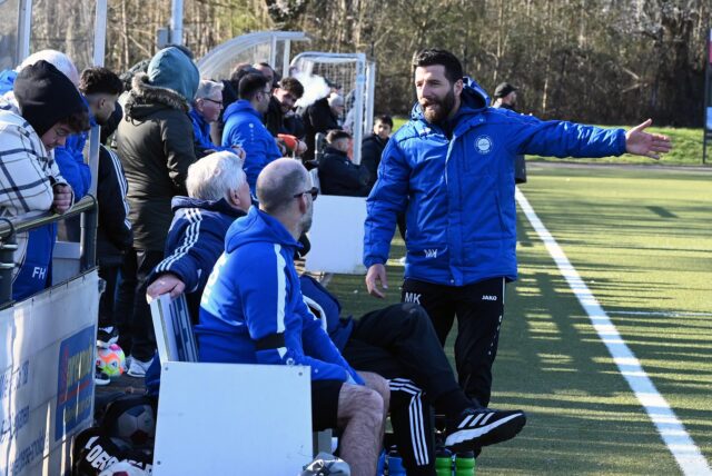 Mehmet Kara steht neben der Bank des VfL Kamen und gestikuliert