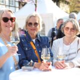 Drei Frauen stehen beim Genussfrühling in Werne an einem Stehtisch und trinken Weißwein.