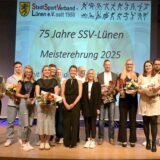 Personen stehen auf der Bühne und halten Blumensträuße und Trophäen in der Hand, da sie als Sportler und Mannschaften der Jahre 2023 und 2024 geehrt wurden.