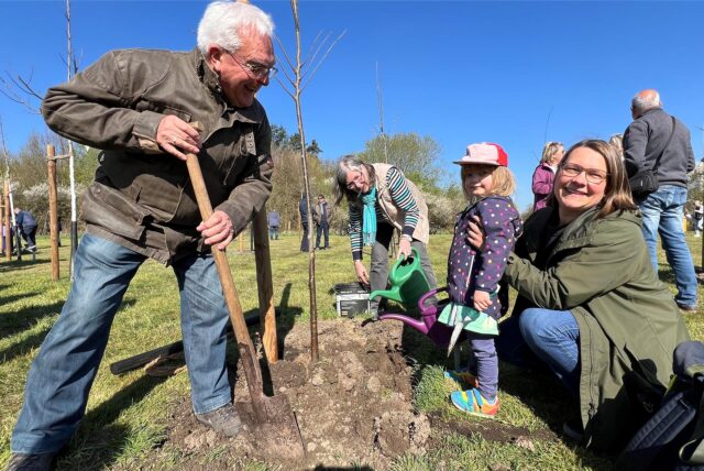 Peter Schäfer pflanzt gemeinsam mit seiner Familie im Bergkamener Jubiläumswald eine Ulme ein.