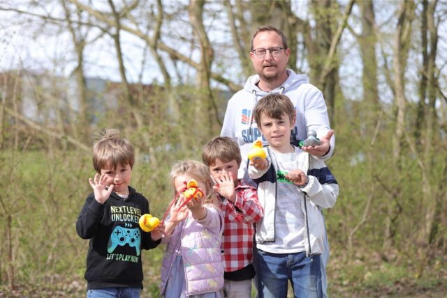 Vier Kinder und ein Erwachsener halten Gummienten in die Kamera.