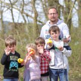 Vier Kinder und ein Erwachsener halten Gummienten in die Kamera.