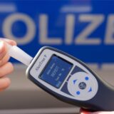 Ein Polizist hält ein Alkohol-Messgerät in der Hand.