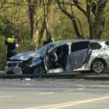 Zwei Polizisten stehen bei einem stark beschädigten Pkw