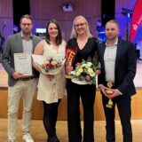 Matthias Hövener (v.l.n.r.), Lara Hövener, Katharina Stember und Steffen Renze stehen mit ihren Urkunden und Blumen vor der Bühne des Hansesaals.