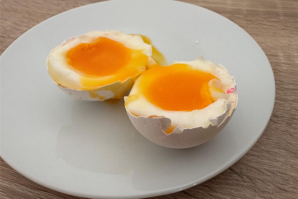 Ein in zwei Hälften geteiltes, weichgekochtes Ei, das im Airfryer gegart wurde.