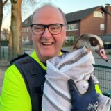 Polizist aus Werne trägt eine Gans auf dem Arm