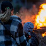 Eine Frau steht mit einem Kind vor einem Osterfeuer in Lünen.