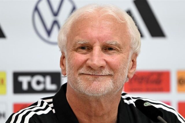 Rudi Völler sitzt bei einer Pressekonferenz auf dem Podium.