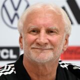 Rudi Völler sitzt bei einer Pressekonferenz auf dem Podium.