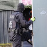 Ein Polizist öffnet eine Tür.
