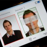 Auf einem Bildschirm ist das Passfoto eines Mann zu sehen, das biometrisch ausgemessen wird.