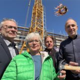 Axel Kunstmann, Barbara Brunsing, Andreas Anspach und Uwe Poganiatz-Heine unter dem Richtkranz vor dem Baukran auf der Baustelle an der Bodelschwingher Straße.