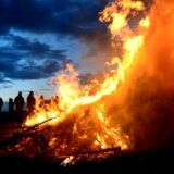 Zuschauer stehen bei einem traditionellen Osterfeuer.