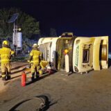 Ein spanischer Sattelzug liegt in der Tangente von der A2 auf die A1 im Kamener Kreuz auf der Seite. Mehrere Feuerwehrleute sind drumherum zu sehen.