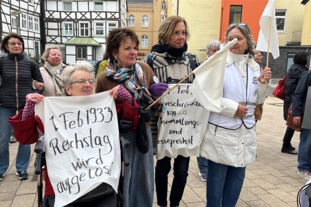 Teilnehmerinnen erinnern bei einer Mahnwache zum 80. Jahrestag des Endes des Zweiten Weltkriegs in Unna an historische Daten der Nazi-Diktatur.