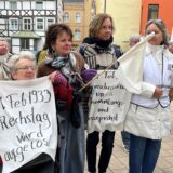 Teilnehmerinnen erinnern bei einer Mahnwache zum 80. Jahrestag des Endes des Zweiten Weltkriegs in Unna an historische Daten der Nazi-Diktatur.