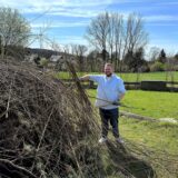 Ein Mann schichtet Schnittholz für ein Osterfeuer auf.