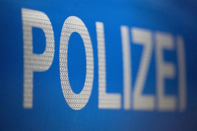 Weißer Schriftzug „Polizei“ auf blauem Hintergrund.