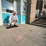 Rudolf Fröhlich (CDU) sitzt vor dem Parteibüro der CDU an der Bahnhofstraße in Unna. Reste vom Kreide-Schmierereien sind noch deutlich erkennbar.