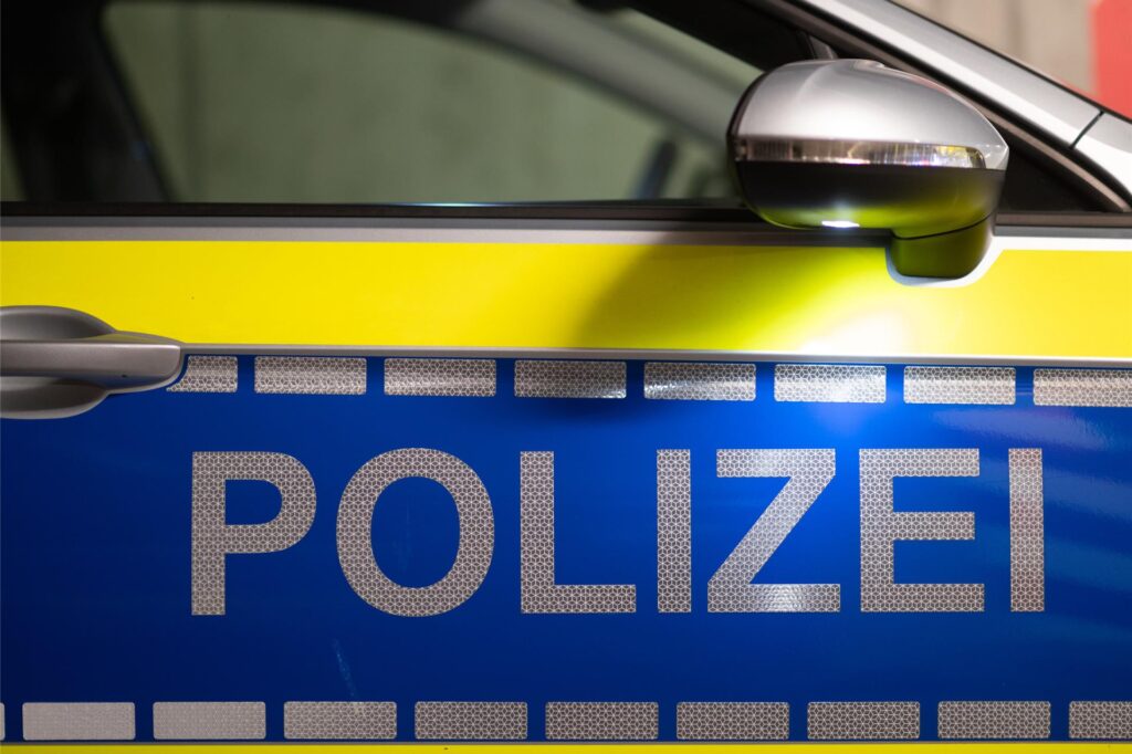 Polizei steht in silbernen Lettern auf einem Fahrzeug. Polizei steht in silbernen Lettern auf einem Fahrzeug.