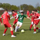 Fünf Fußballspieler kämpfen um den Ball.