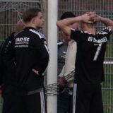 Spieler und Funktionäre des BV Brambauer stehen um einen Torpfosten und einer verschlossenen Kette.