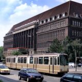 Ein altes Foto des ehemaligen Versorgungsamts in Dortmund, im Vordergrund Autos und eine Straßenbahn