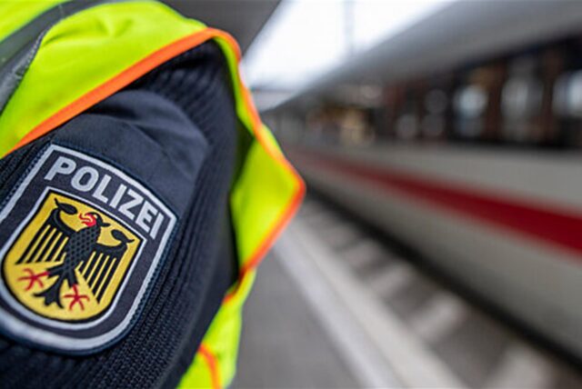 Ein Bundespolizist steht an einem Bahnhof vor einem ICE.