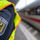 Ein Bundespolizist steht an einem Bahnhof vor einem ICE.