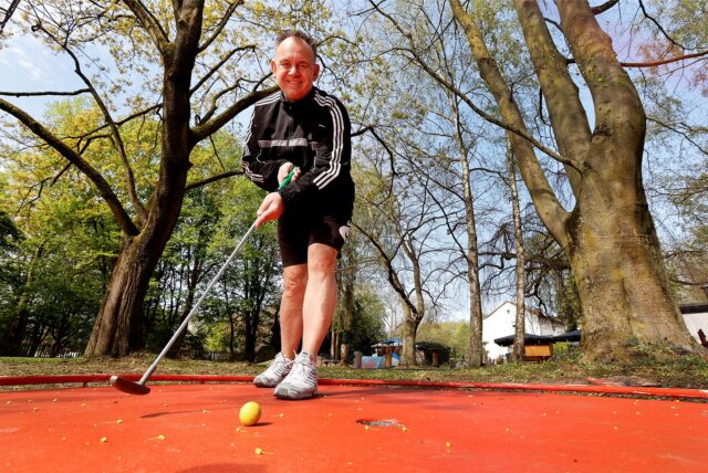 Betreiber Jens Naujokat auf seiner Minigolfanlage an der Dürerstraße. Er hält einen Minigolfschläger.