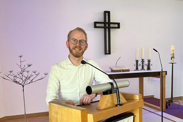 Pfarrer Niklas Peuckmann steht am Ambo im Kirchenraum des Johannes-Buxtorf-Hauses in Südkamen.
