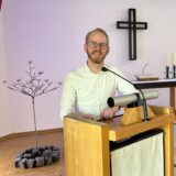 Pfarrer Niklas Peuckmann steht am Ambo im Kirchenraum des Johannes-Buxtorf-Hauses in Südkamen.