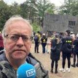 Kundgebungsteilnehmer betrachten die niedergelegten Kränze am Mahnmal für die NS-Opfer in der Bittermark.