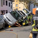 Ein Mercedes liegt über geparkten Autos. Rettungskräfte sichern ein Auto, das schräg auf mehreren geparkten Fahrzeugen zum Stehen gekommen ist.