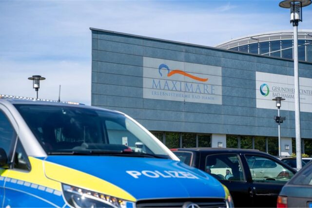 Ein Polizeiwagen steht vor einem Schwimmbad.