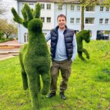 Yevhen Somin mit einem Rentier und einem Pferd im Kunstrasen-Look.