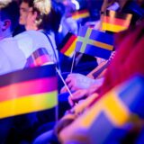 Zuschauer halten vor Beginn des Eurovision Song Contest die Fähnchen von Deutschland und Schweden in den Händen.
