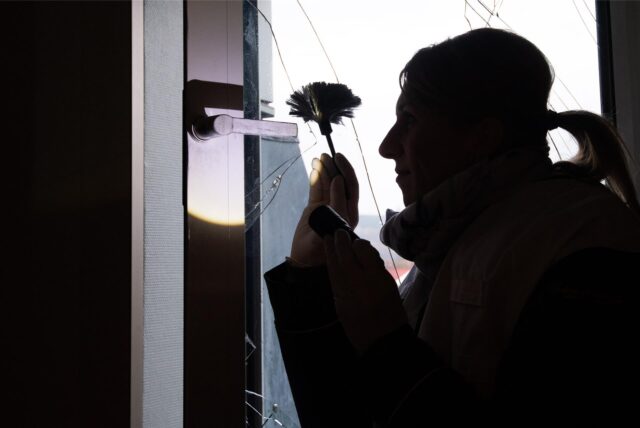 Eine Polizistin sichert Spuren an einem beschädigten Fenster.