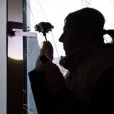 Eine Polizistin sichert Spuren an einem beschädigten Fenster.
