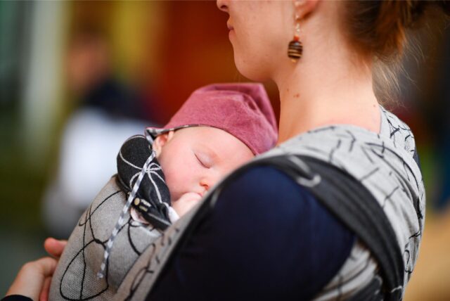 Eine Frau hält ein Baby auf dem Arm.
